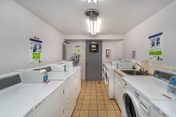 A laundromat with a row of washers and dryers.